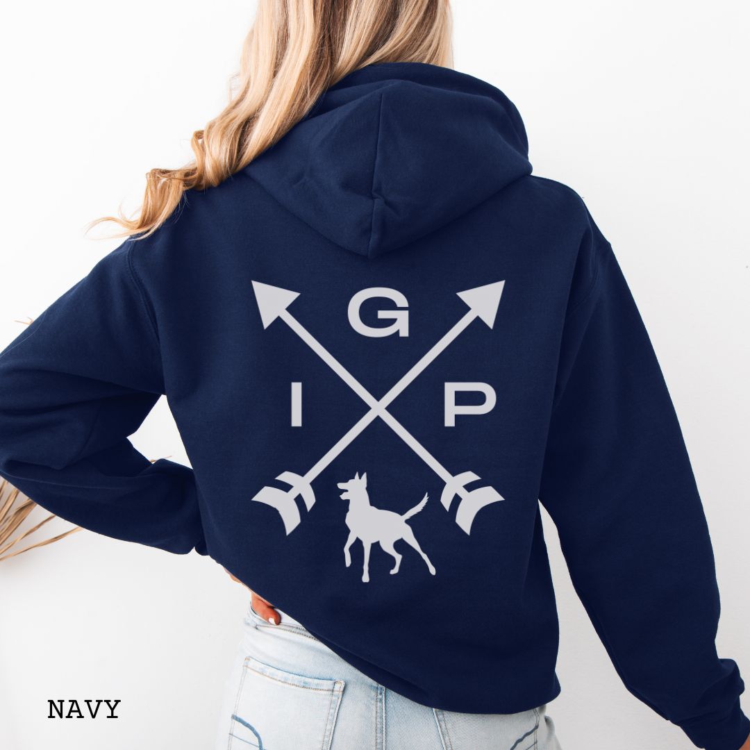 Navy blue Schutzhund/IGP hoodie with crossed arrows design with 'IGP' text and Belgian Malinois on the back, presented on a wooden surface with accessories.
