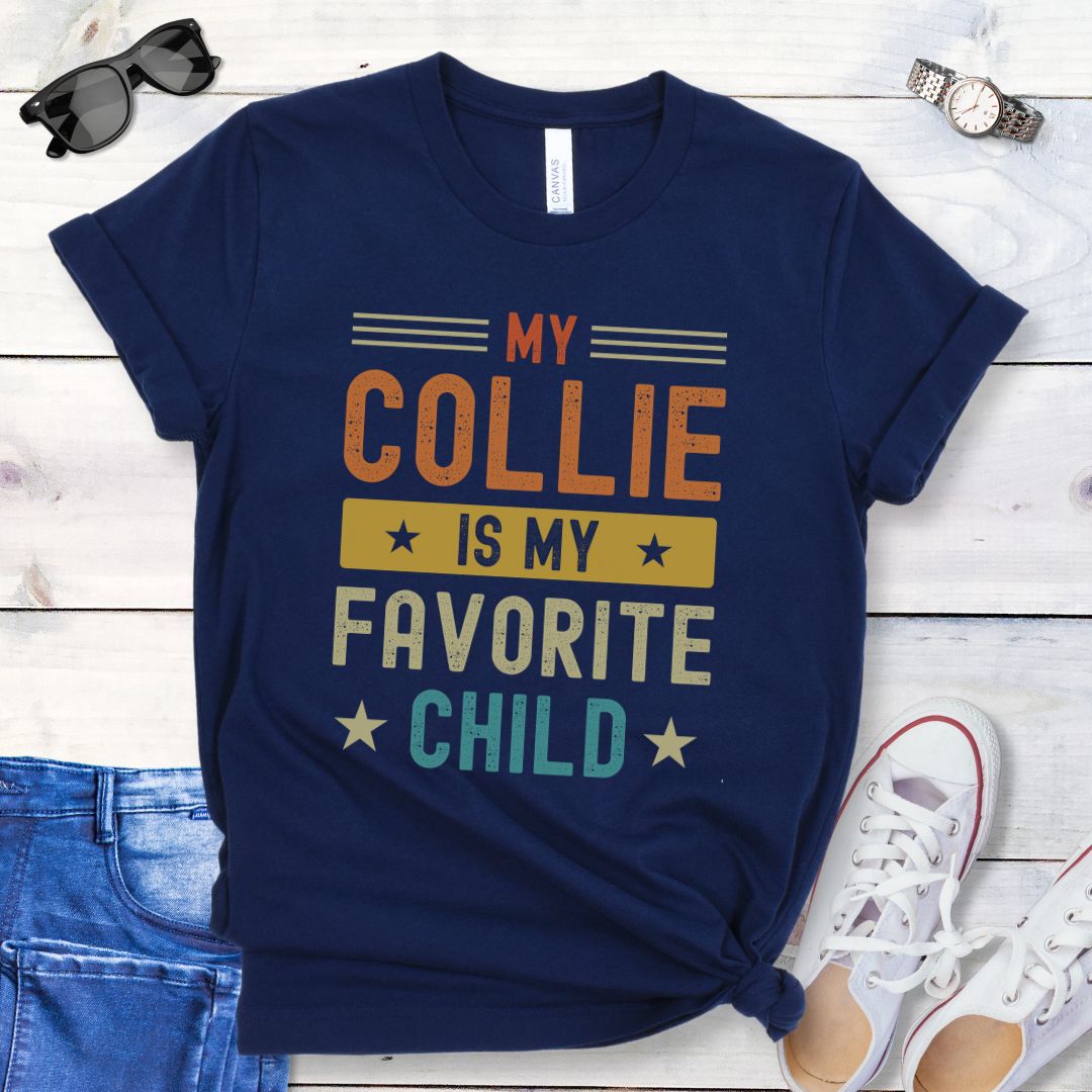 Navy t-shirt for Rough Collie lovers with humorous text 'My Collie is my Favorite Child' in bold colorful retro lettering, shown on a wooden surface with jeans and shoes.