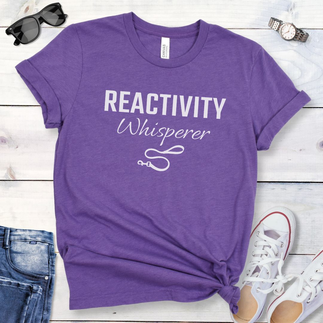 Purple unisex t-shirt featuring a Reactivity Whisperer  text design with leash graphic, a funny reactive dog trainer shirt for dog training professionals.