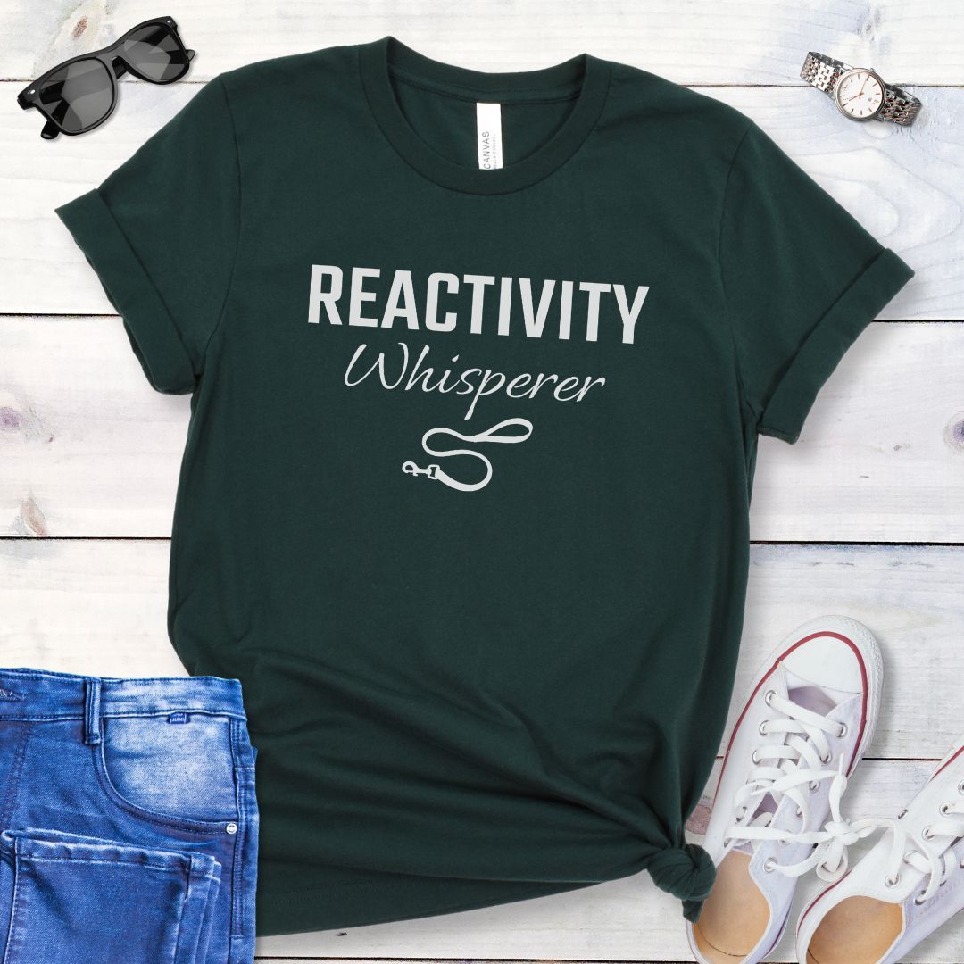 Dark grey unisex t-shirt featuring a Reactivity Whisperer  text design with leash graphic, a funny reactive dog trainer shirt for dog training professionals.