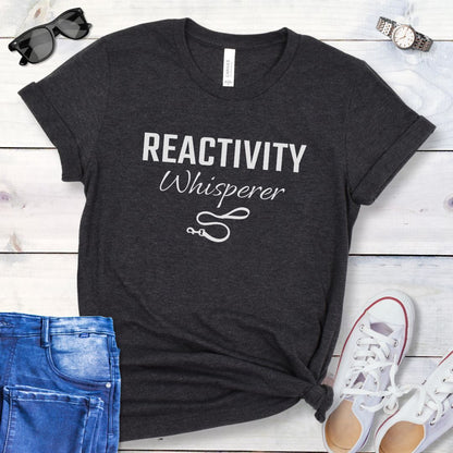 Grey unisex t-shirt featuring a Reactivity Whisperer  text design with leash graphic, a funny reactive dog trainer shirt for dog training professionals.