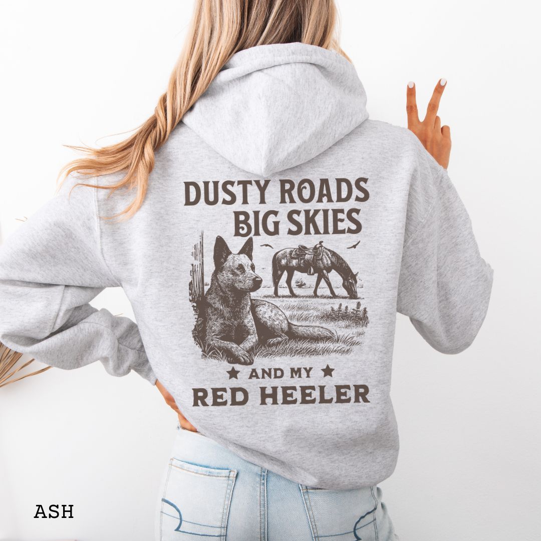 Back view of light grey Red Heeler hoodie featuring a Western-style design with grazing horse, rustic fence, and an Cattle Dog illustration; text reads “Dusty Roads, Big Skies, and My Red Heeler.”