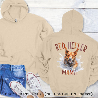 Beige hoodie with red heeler graphic and 'Red Heeler Mama' text, displayed with jeans and sneakers on a wooden surface.