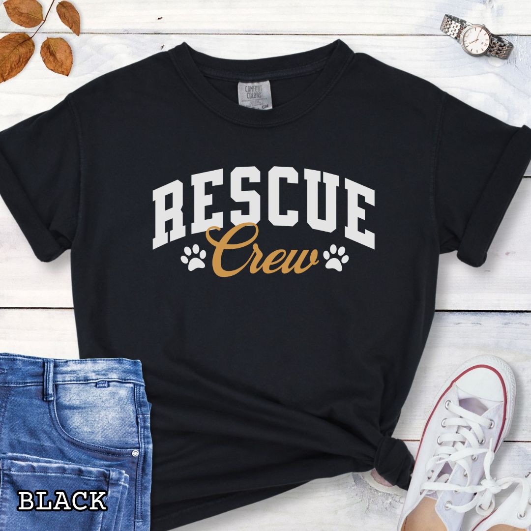 Black Comfort Colors t-shirt featuring bold college-style Rescue Crew text with paw prints, perfect for rescue dog lovers, dog adoption advocates, fosters, and rescue volunteers.