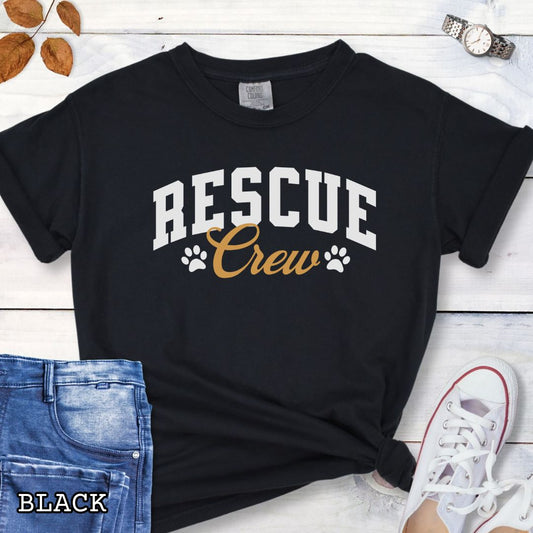 Black Comfort Colors t-shirt featuring bold college-style Rescue Crew text with paw prints, perfect for rescue dog lovers, dog adoption advocates, fosters, and rescue volunteers.