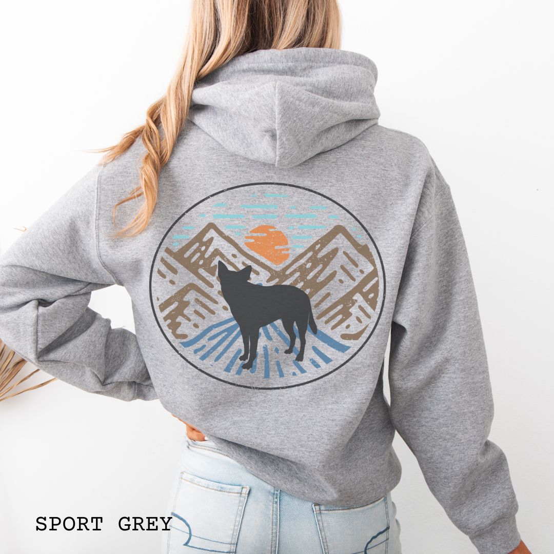 Grey Cattle Dog hoodie with a Heeler and retro mountain design on the back, worn by a person.