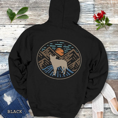 Black Cattle Dog hoodie with a Heeler and retro mountain design on the back, presented on a wooden background with accessories.