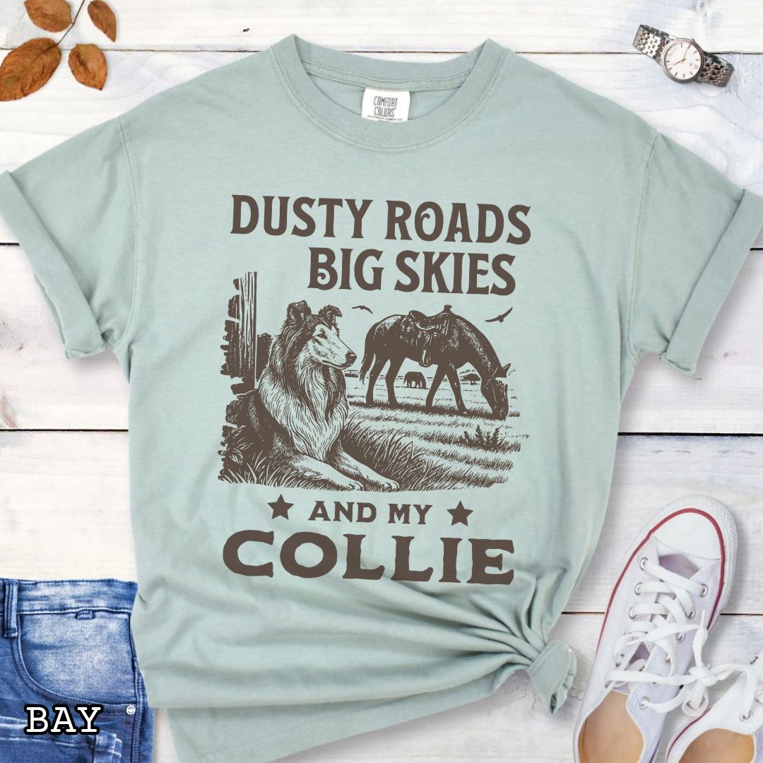 Bay green Comfort Colors t-shirt featuring a Western-style design with grazing horse, rustic fence, and a Rough Collie illustration; text reads “Dusty Roads, Big Skies, and My Collie.”