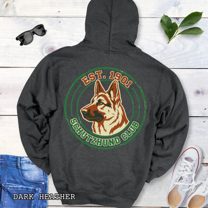 Dark grey back print hoodie with a  German Shepherd Dog and 'Established 1901, Schutzhund Club' text in a circular logo style design, displayed on a wooden surface with flowers and jeans.