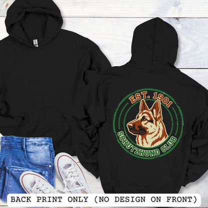 Black back print hoodie with a  German Shepherd Dog and 'Established 1901, Schutzhund Club' text in a circular logo style design, displayed on a wooden surface with flowers and jeans.