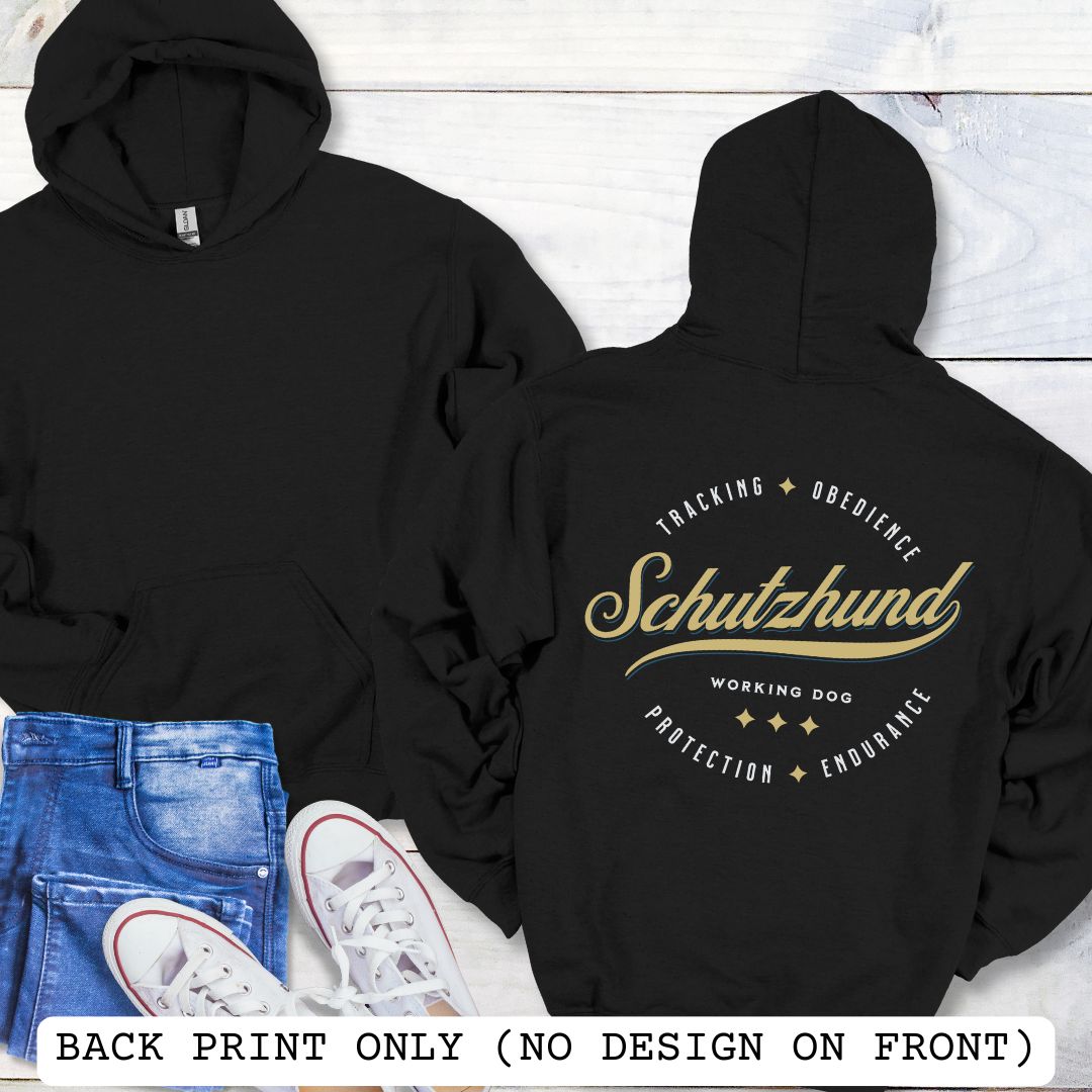 Back view of a black unisex Schutzhund/IGP hoodie with vintage style text design that reads 'Schutzhund, Working Dog, Tracking, Obedience, Protection, Endurance'. Presented on a wooden background with jeans and shoes.