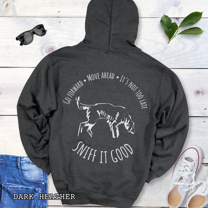 Dark grey heather scent work hoodie with a graphic print of a dog sniffing and text that reads 'Sniff It Good'. The shirt is presented flat with casual clothing and shoes.