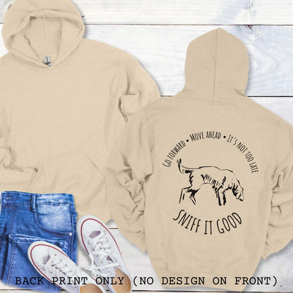 Beige scent work hoodie with a graphic print of a dog sniffing and text that reads 'Sniff It Good'. The shirt is presented flat with casual clothing and shoes.