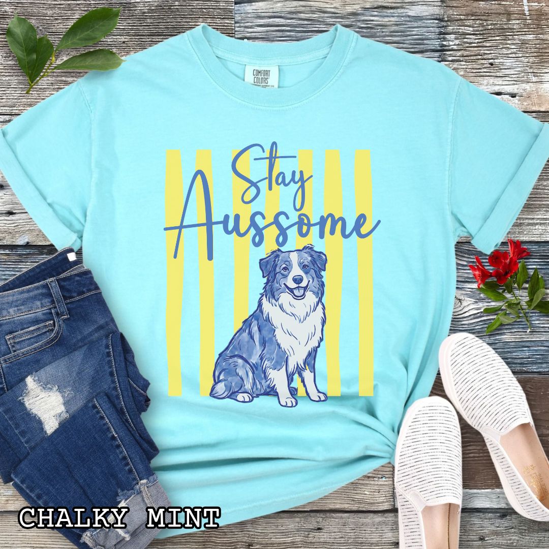Mint Comfort Colors Australian Shepherd t-shirt featuring Stay Aussome slogan with cute blue merle Aussie illustration, perfect for Aussie moms, herding dog lovers, and Australian Shepherd gifts.