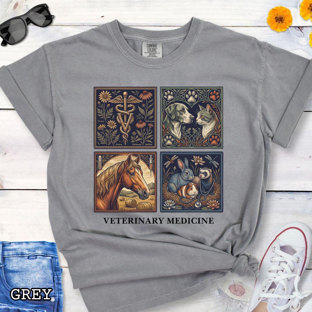 Grey Comfort Colors t-shirt with vintage linocut-style veterinary-themed design in four panels and the text 'Veterinary Medicine', shown on a wooden surface with jeans and flowers.