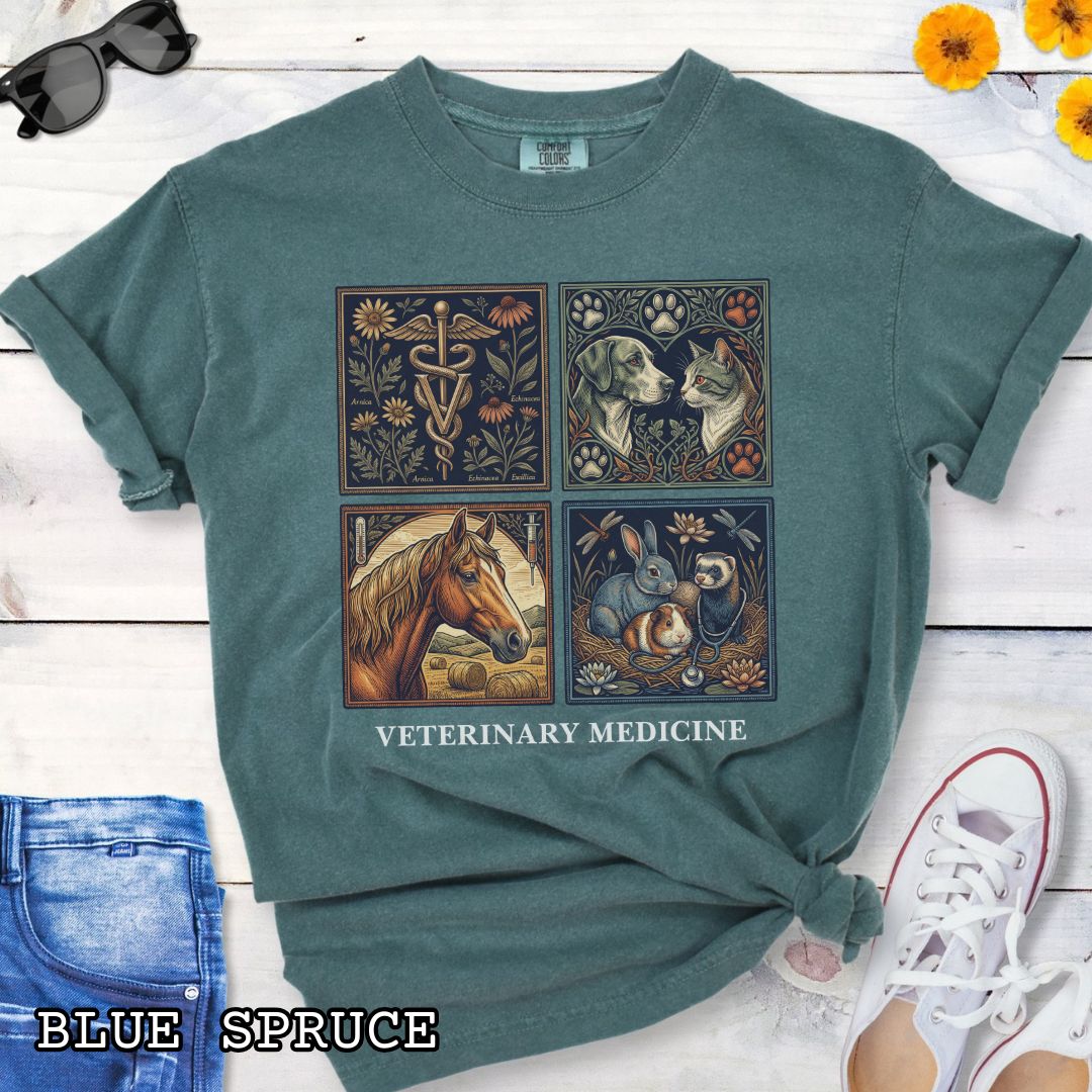 Green Comfort Colors t-shirt with vintage linocut-style veterinary-themed design in four panels and the text 'Veterinary Medicine', shown on a wooden surface with jeans and flowers.