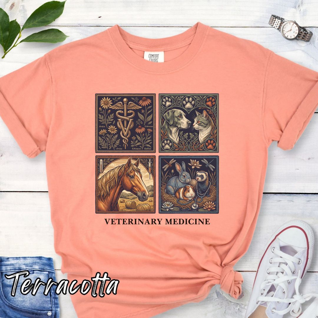 Terracotta Comfort Colors t-shirt with vintage linocut-style veterinary-themed design in four panels and the text 'Veterinary Medicine', shown on a wooden surface with jeans and flowers.