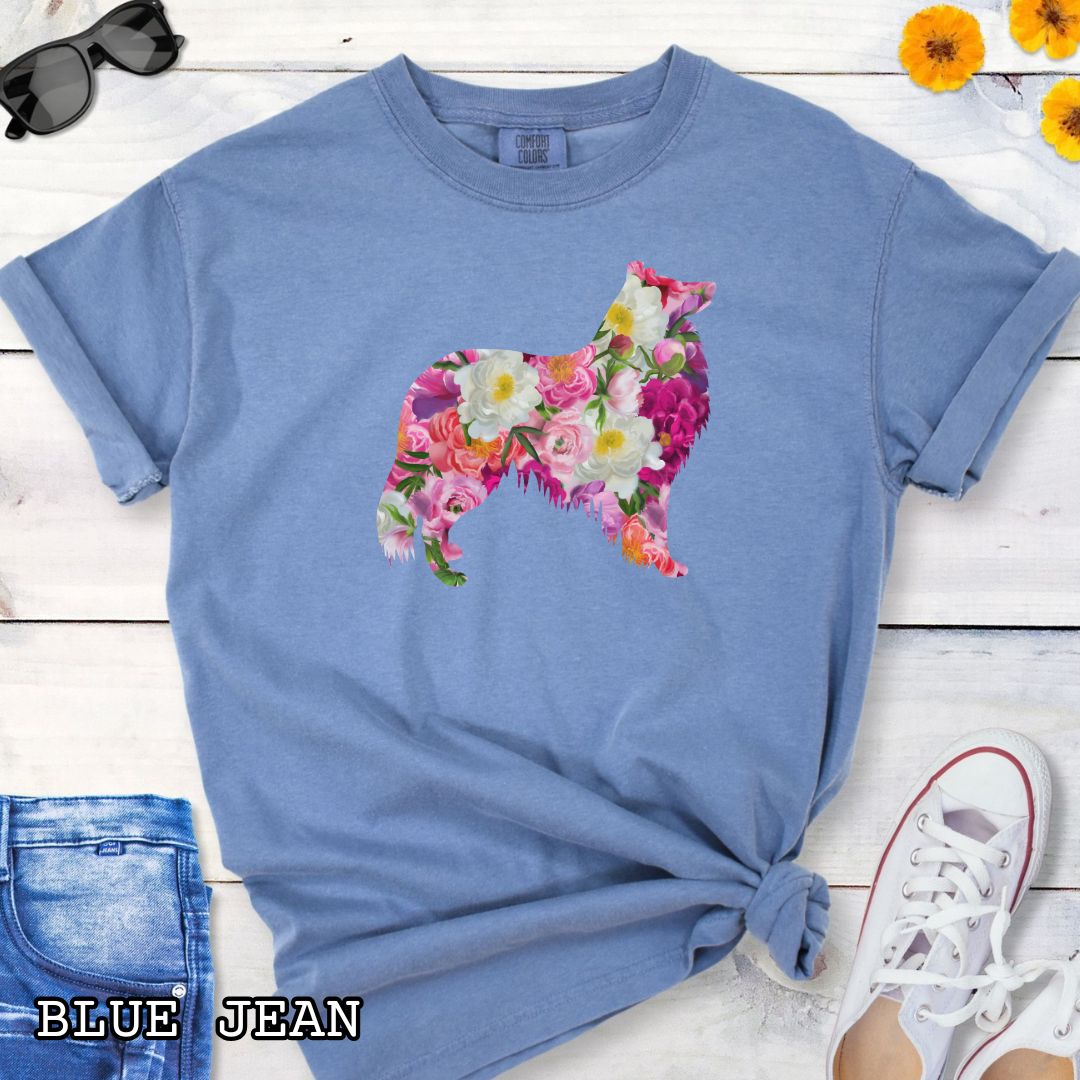 Blue Comfort Colors t-shirt for Collie lovers with floral Rough Collie dog design, shown on a wooden surface with jeans and flowers.
