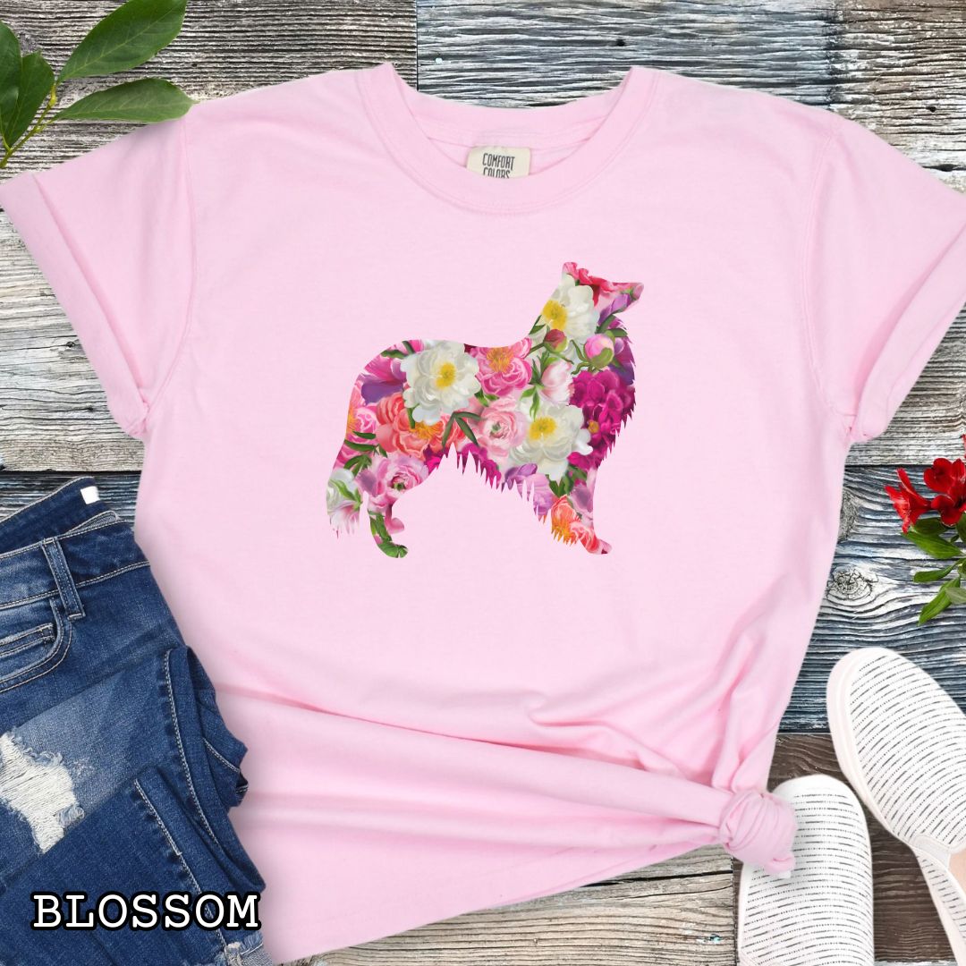 Pink Comfort Colors t-shirt for Collie lovers with floral Rough Collie dog design, shown on a wooden surface with jeans and flowers.