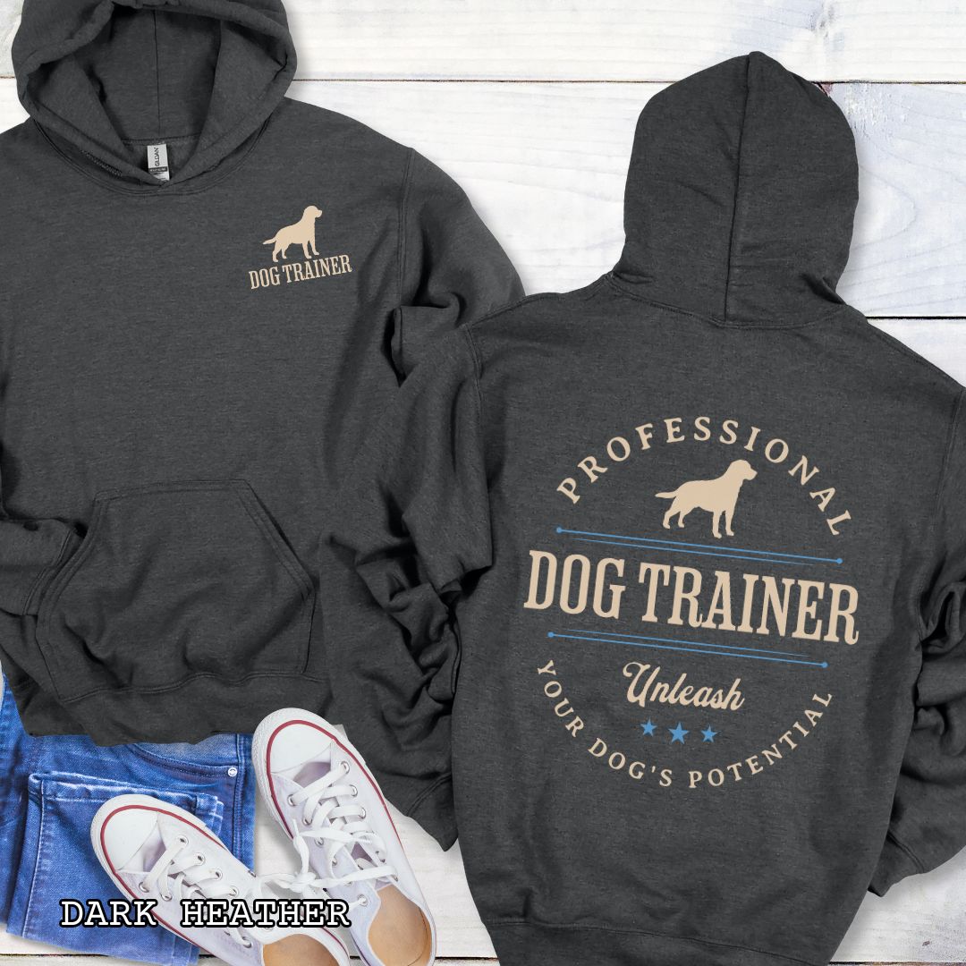 Front and back view of a dark grey dog training hoodie with the text 'PROFESSIONAL DOG TRAINER, Unleash Your Dog's Potential"' and custom dog breed silhouette in a vintage, badge style design. The shirt is displayed flat with a pair of blue jeans and white shoes.