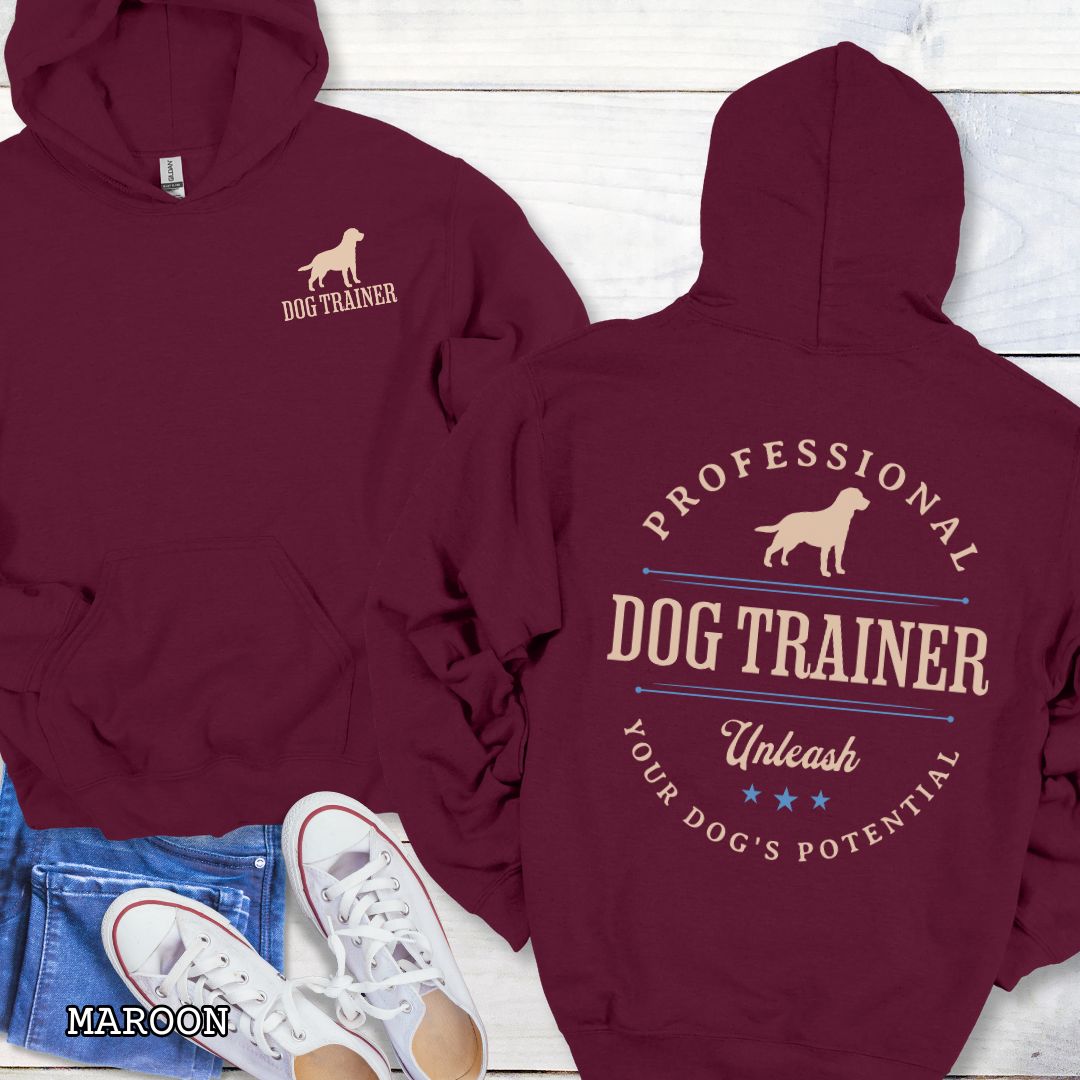 Front and back view of a maroon dog training hoodie with the text 'PROFESSIONAL DOG TRAINER, Unleash Your Dog's Potential"' and custom dog breed silhouette in a vintage, badge style design. The shirt is displayed flat with a pair of blue jeans and white shoes.