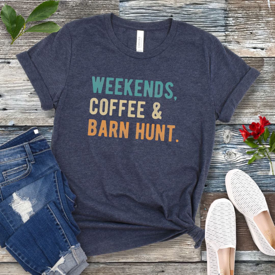 Heather navy dog sports t-shirt with 'Weekends, Coffee & Barn Hunt' in bold, colorful text, presented on a wooden surface with jeans and shoes.