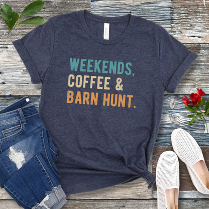 Heather navy dog sports t-shirt with 'Weekends, Coffee & Barn Hunt' in bold, colorful text, presented on a wooden surface with jeans and shoes.
